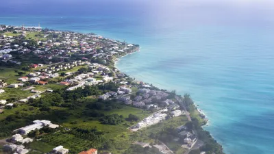 Karibische Küstenlandschaft mit bunten Häusern und türkisfarbenem Meer.