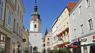 Historische Gasse in Krems mit Kirchturm und bunten Häusern