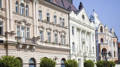Historische Gebäude säumen eine belebte Straße in Novi Sad.