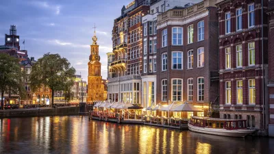 Amsterdam-Kanal mit beleuchteten Häusern und Booten bei Nacht