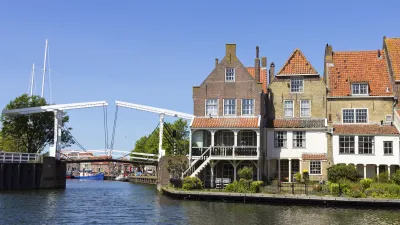 Historische Häuser säumen einen Kanal mit einer Brücke in Enkhuizen.