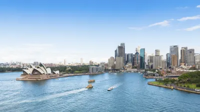 Sydney Opernhaus und Skyline mit Booten auf dem Wasser.