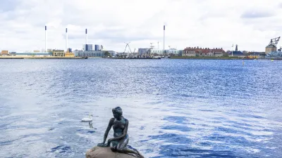 Die kleine Meerjungfrau sitzt auf einem Felsen im Wasser