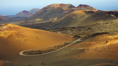 Vulkanlandschaft mit kurviger Straße auf Lanzarote.