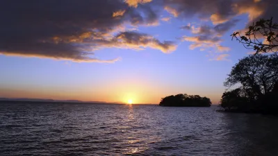 Sonnenuntergang über dem See mit Insel im Hintergrund