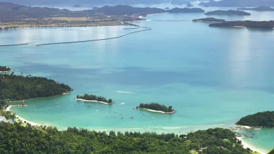 Türkisblaues Meer mit kleinen Inseln und üppiger Vegetation am Strand.
