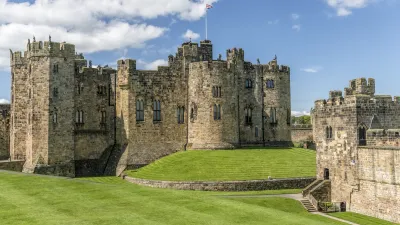 Alnwick Castle erhebt sich majestätisch auf einem grünen Hügel.