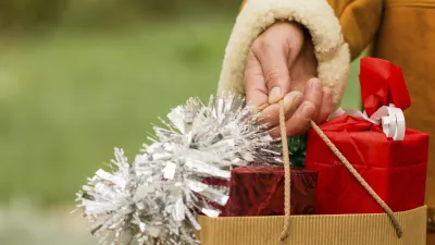 Weihnachtsgeschenke in einer Papiertüte werden von einer Person getragen