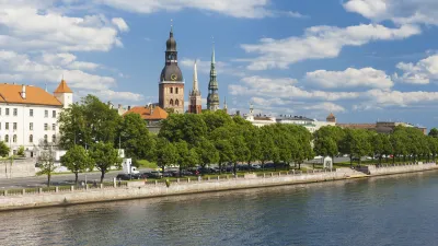 Rigaer Dom und Uferpromenade mit Bäumen an einem sonnigen Tag.