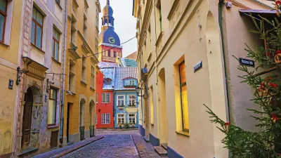 Bunte Häuser säumen die gepflasterte Gasse in Rigas Altstadt