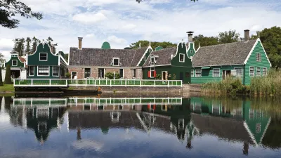 Grünes traditionelles niederländisches Haus spiegelt sich im Wasser.