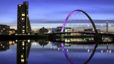 Die beleuchtete Brücke über den Fluss bei Nacht in Glasgow.