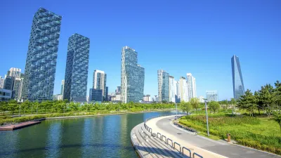 Moderne Wolkenkratzer spiegeln sich im Wasser eines Parks.