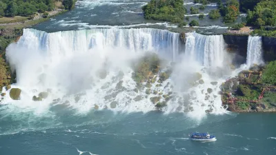 Niagara-Wasserfälle mit tosendem Wasser und einem Boot im Vordergrund.