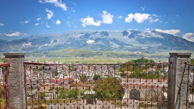Blick über Gjirokastra mit blühenden Blumen im Vordergrund