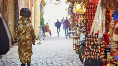 Eine Frau geht durch eine belebte Gasse in Marrakesch.