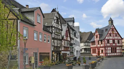 Historische Fachwerkhäuser säumen eine belebte Gasse in Cochem.