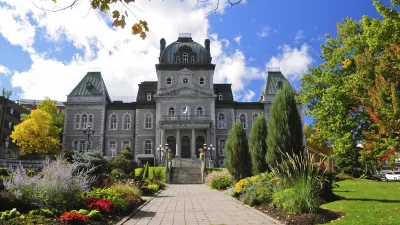 Historische Stadthalle mit gepflegtem Blumengarten im Herbst.