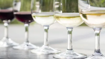 Verschiedene Weinsorten stehen in Gläsern auf einem Holztisch.