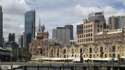 Historische Lagerhäuser säumen den Hafen von Sydney mit modernen Wolkenkratzern im Hintergrund.