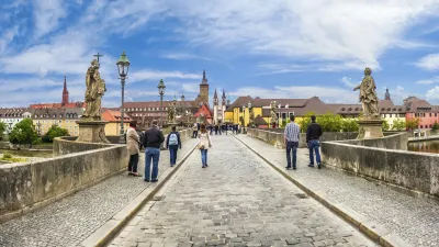 Historische Mainbrücke in Würzburg mit Fußgängern und Stadtkulisse