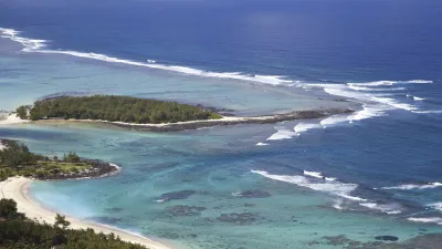 Türkisblaues Meer umspült eine kleine Insel mit weißem Sandstrand.