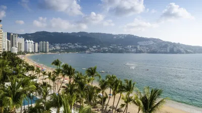 Palmen säumen den goldenen Strand von Acapulco mit Blick auf das blaue Meer.