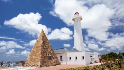 Weißer Leuchtturm und Denkmal an der Küste Südafrikas