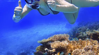 Schnorchelnde Frau gibt im Meer ein Daumen hoch