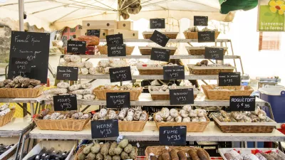 Wurstwaren und Käse werden auf einem Marktstand präsentiert