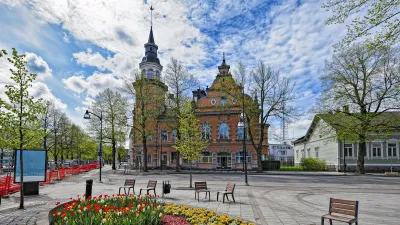 Historisches Gebäude mit Turm und bunten Blumenbeeten im Zentrum von Rauma, Finnland