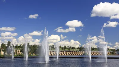 Springbrunnen vor einer grünen Landschaft unter blauem Himmel