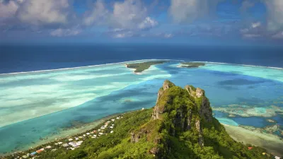 Grüne Berglandschaft mit Blick auf türkisfarbenes Meer und Inseln.