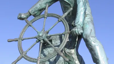 Ein Fischer hält entschlossen ein Steuerrad.