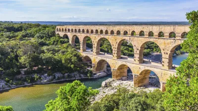 Der Pont du Gard, ein antikes römisches Aquädukt, überspannt einen Fluss.