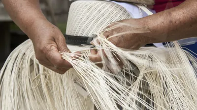 Flechter formt Strohhalme zu einem traditionellen Panama-Hut.