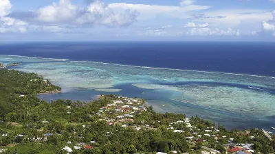 Blick auf die malerische Opunohu-Bucht mit bunten Häusern und türkisfarbenem Wasser.