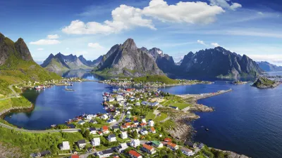 Dorf Reine in den Lofoten mit Blick auf die umgebenden Berge und das blaue Meer.
