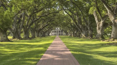 Historisches Herrenhaus am Ende einer von Eichen gesäumten Allee
