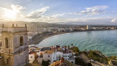 Historischer Glockenturm überblickt die Küstenstadt und das blaue Meer.