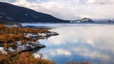 Uferlandschaft mit bunten Bäumen und Bergpanorama am Wasser