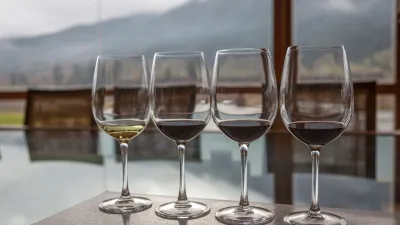 Vier Weingläser mit unterschiedlichen Weinsorten stehen auf einem Tisch.