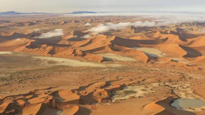 Wüstenlandschaft mit Sanddünen und trockenem Flussbett in Namibia