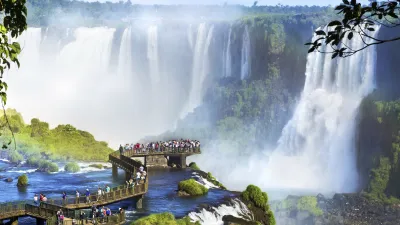 Touristen bestaunen die beeindruckenden Iguazu-Wasserfälle mit viel Wasser.