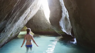 Frau schwimmt in einem türkisfarbenen Felsental