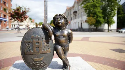 Bronze-Statue eines kleinen Jungen neben einem Wappen