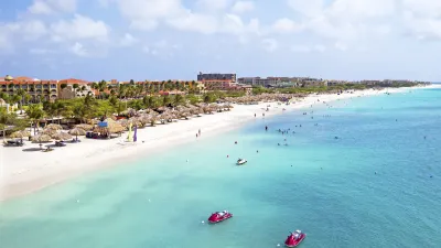 Wunderschöner Strand mit türkisfarbenem Wasser und vielen Badegästen.