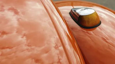 Reflektierender Oldtimer mit orangefarbenem Lack und Chromdetails.