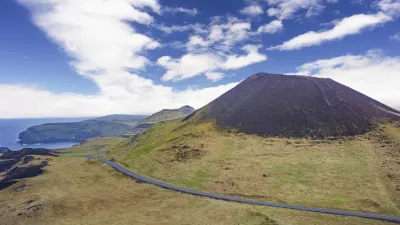 Vulkan Eldfell erhebt sich über der grünen Landschaft von Heimaey Island.