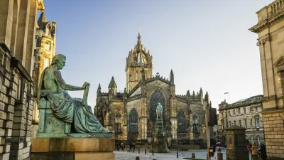 Eine Bronzestatue sitzt vor der historischen Kirche St. Giles auf der Royal Mile in Edinburgh.